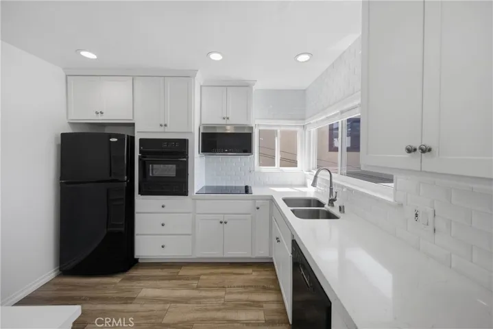 Beautiful bright quartz countertops, tile backsplash, all appliances included, and wood flooring.