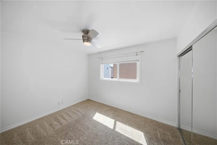Second primary bedroom with ceiling fan and spacious closet.