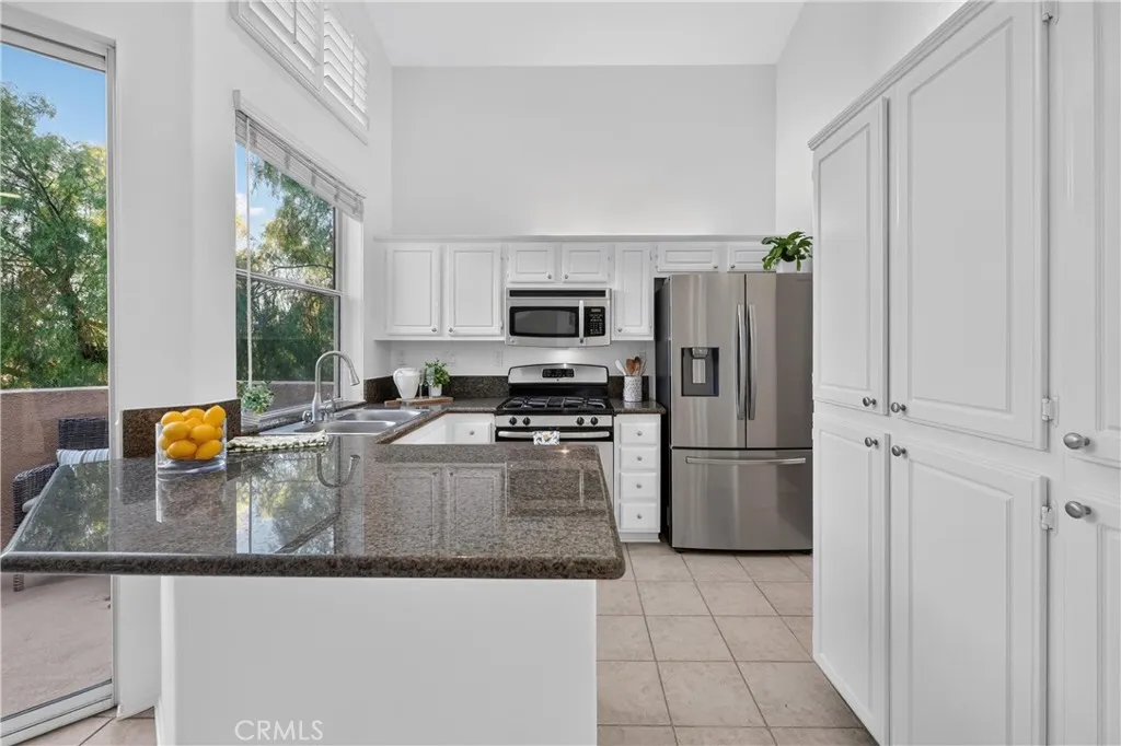 White wood cabinetry, stainless steal appliances and granite counter tops with lots of natural light White wood cabinetry, stainless steal appliances and granite counter tops with lots of natural light