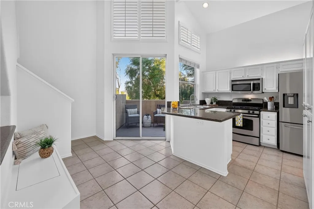 Open kitchen with high ceilings, lots of natural light with custom bench at breakfast nook and direct access to patio with great views. Open kitchen with high ceilings, lots of natural light with custom bench at breakfast nook and direct access to patio with great views.