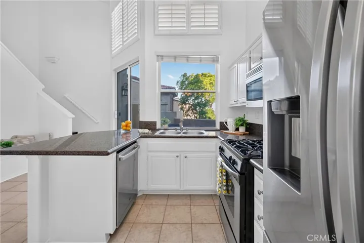 White wood cabinetry, stainless steal appliances and granite counter tops with lots of natural light