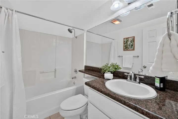 Second full bathroom off hallway with shower in tub and granite counter tops