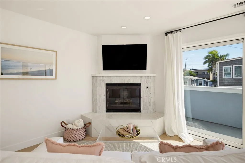 Family room with corner fireplace, and sliding doors opening to the ocean view balcony Family room with corner fireplace, and sliding doors opening to the ocean view balcony