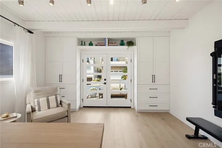 Thoughtfully designed cabinetry surrounding the French doors provide hanging closet space shelves and drawers. No additional furniture needed.