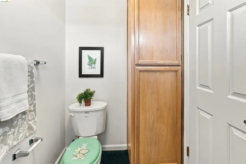Built-in wood-finish cabinetry, white paneled door, and chrome towel bars