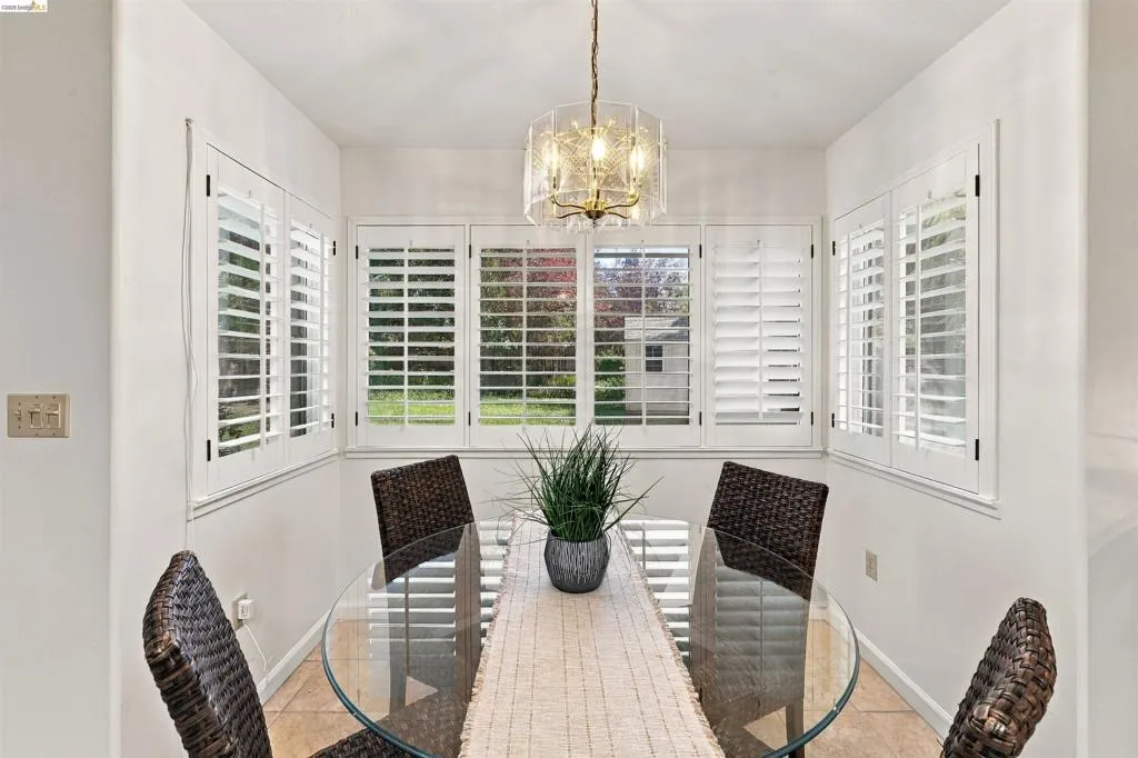 Recessed lighting, tiled flooring, chandelier lighting, white plantation shutters, and multiple windows