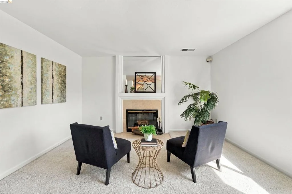 Recessed fireplace with hearth, mirrored surround, and white mantel