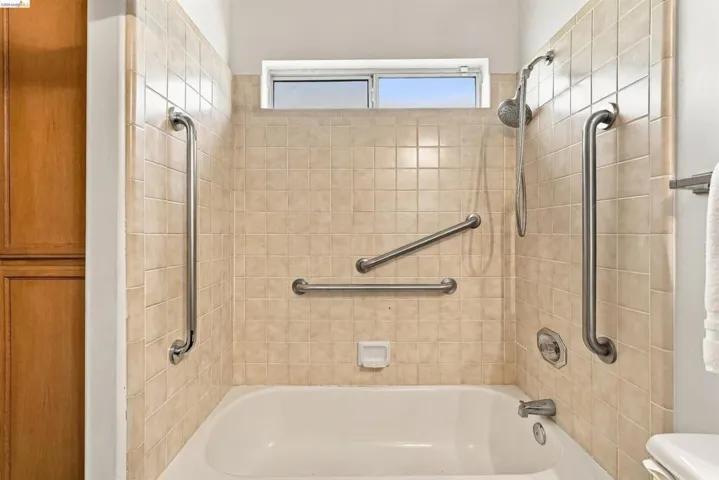 Tub and shower combination with beige square tile surround