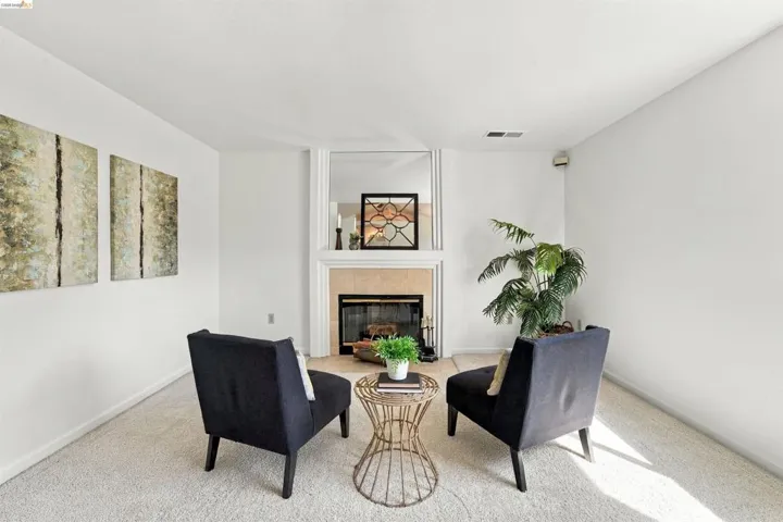 Recessed fireplace with hearth, mirrored surround, and white mantel