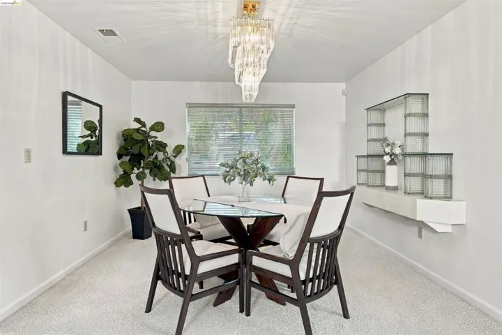 Recessed lighting, window with blinds, wall-mounted glass block shelving, and wall-to-wall carpeting