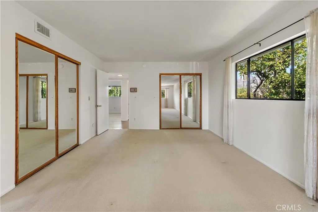 Large primary bedroom with a view & 2 good-size mirrored wardrobe closets
