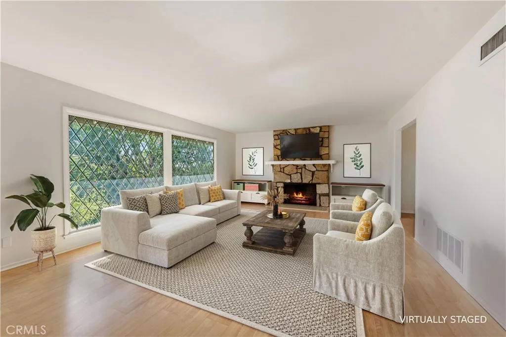 Large living room with stunning beveled windows & a floor to ceiling fireplace