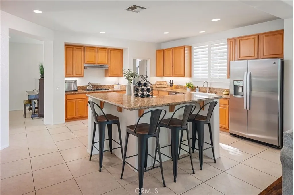 Spacious kitchen with a center island and breakfast bar, perfect for gathering and entertaining.