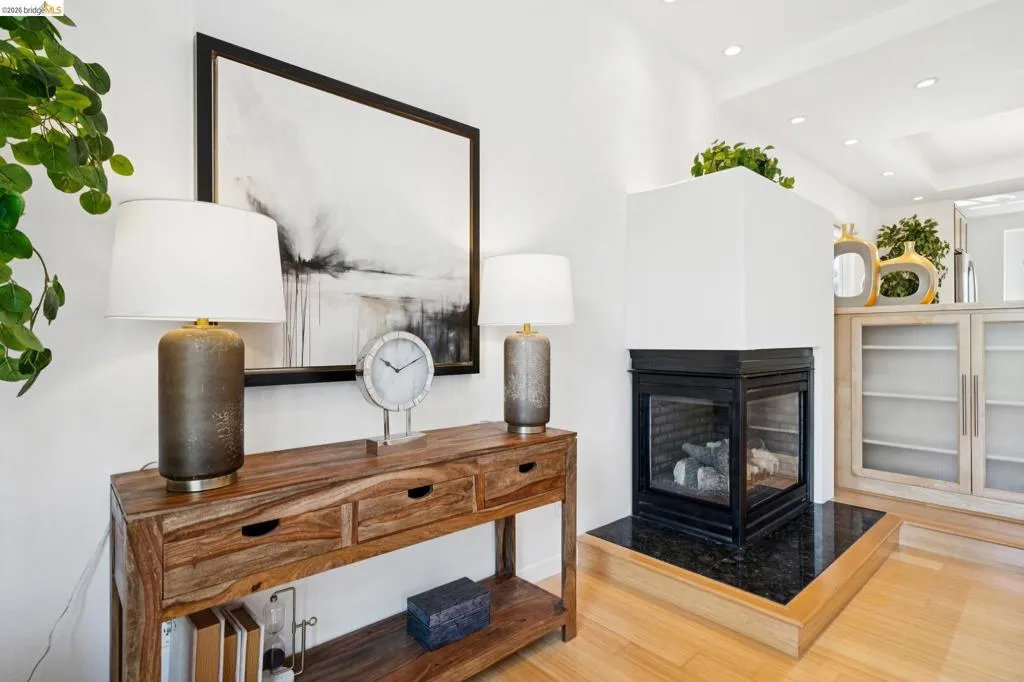 Modern fireplace with a black glass enclosure and a black stone hearth Modern fireplace with a black glass enclosure and a black stone hearth