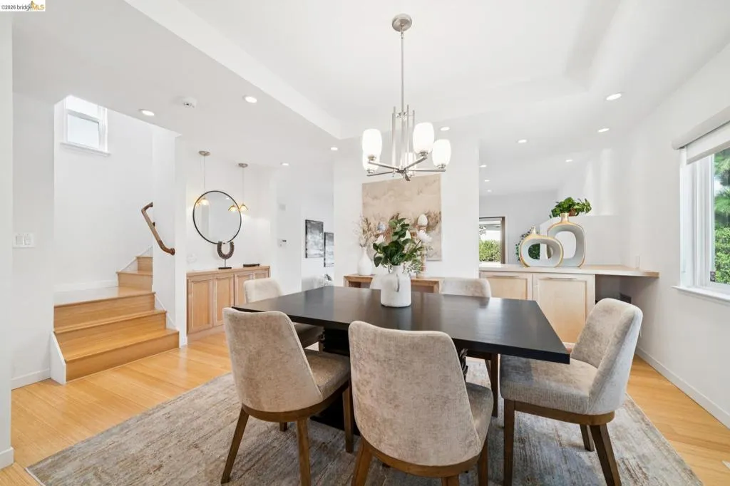 Recessed lighting, light wood-finish flooring, built-in cabinetry, and a contemporary chandelier illuminate this dining area Recessed lighting, light wood-finish flooring, built-in cabinetry, and a contemporary chandelier illuminate this dining area