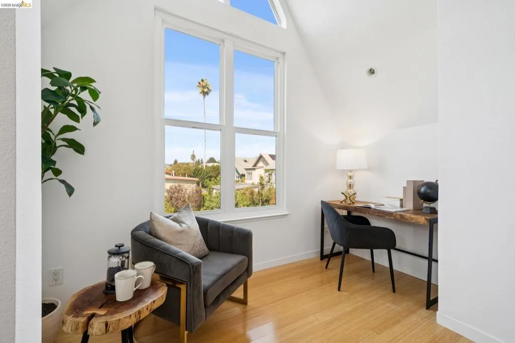 High vaulted ceilings with an upper window, large multi-pane windows, and light wood-finish flooring High vaulted ceilings with an upper window, large multi-pane windows, and light wood-finish flooring