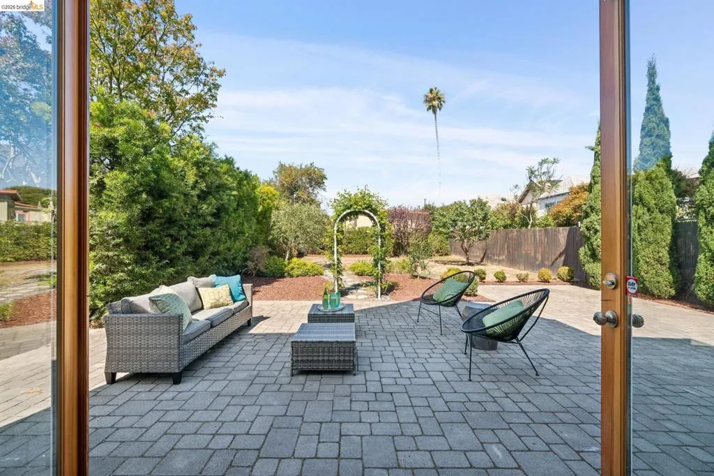 Expansive paver patio with landscaped garden beds and a decorative garden arch Expansive paver patio with landscaped garden beds and a decorative garden arch