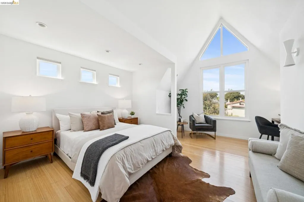Vaulted white ceilings, wood-finish flooring, a large A-frame window, and three clerestory windows Vaulted white ceilings, wood-finish flooring, a large A-frame window, and three clerestory windows