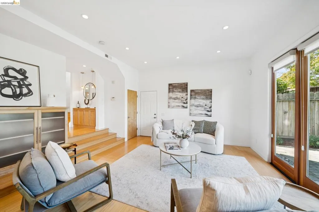 Recessed lighting, wood-finish flooring, white walls, wood-framed glass patio door, and built-in cabinetry with frosted glass panels Recessed lighting, wood-finish flooring, white walls, wood-framed glass patio door, and built-in cabinetry with frosted glass panels
