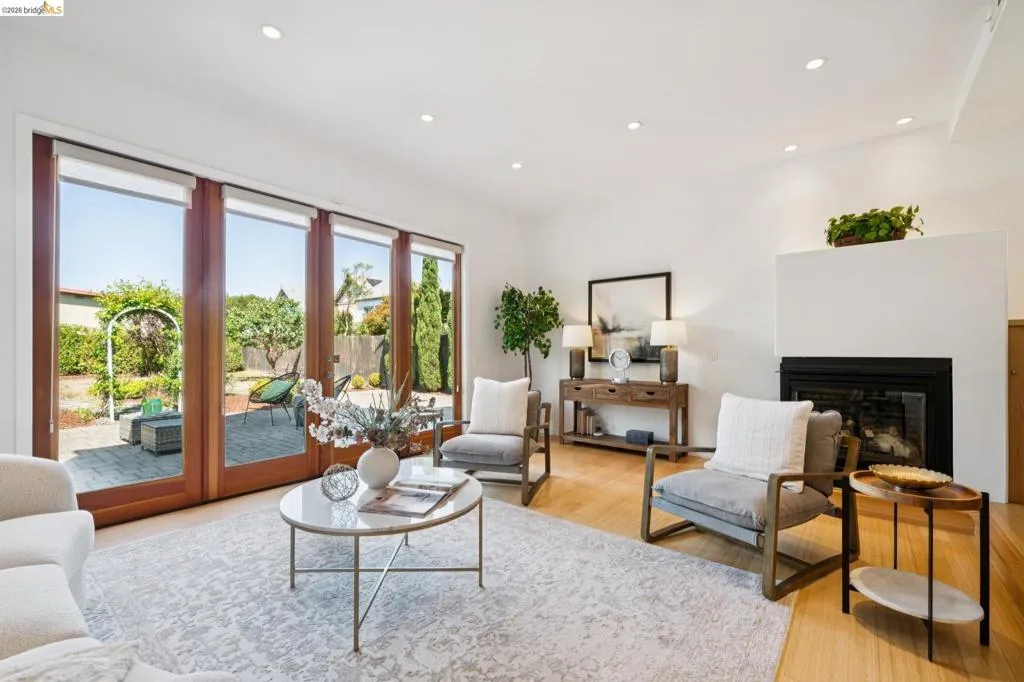 Hardwood flooring, recessed lighting, and a fireplace with a white mantel Hardwood flooring, recessed lighting, and a fireplace with a white mantel