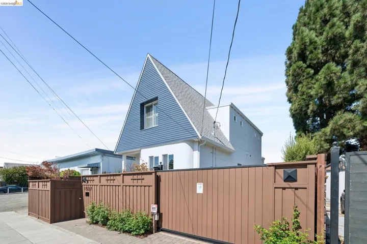 Contemporary architectural style with a prominent peaked roofline and blue siding