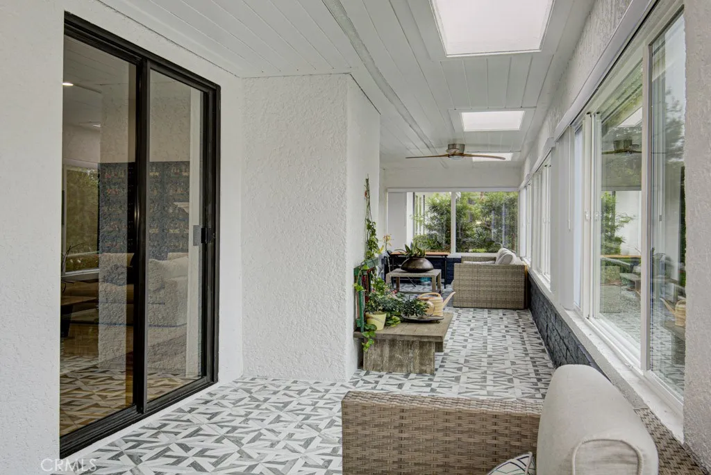 Enclosed and covered rear patio has skylights and ceiling fans and extends the length of the residence. Enclosed and covered rear patio has skylights and ceiling fans and extends the length of the residence.
