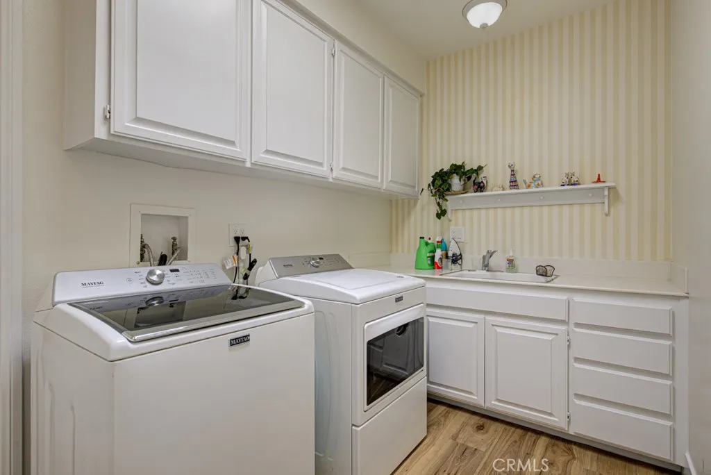 Separate laundry room features cabinet storage and utility sink. Separate laundry room features cabinet storage and utility sink.