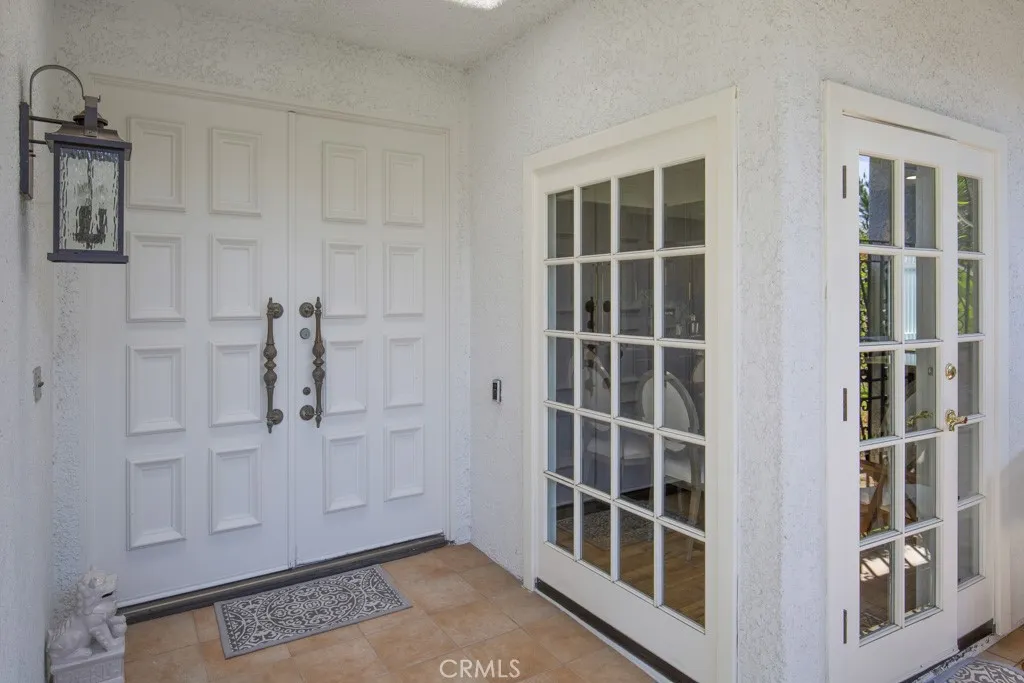 Double door entry into the residence. Separate entry into the breakfast nook in the kitchen can be seen at far right. Double door entry into the residence. Separate entry into the breakfast nook in the kitchen can be seen at far right.