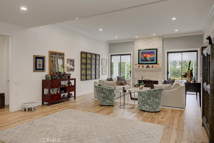 Spacious living room allows for various configurations of your largest furnishings. This room boasts 11' ceilings and a lovely wood-burning gas fireplace backed by a graceful floor-to-ceiling stacked stone wall. Multiple entries to the enclosed covered rear patio on either side of the fireplace. Note the multiple dimmable recessed lighting.