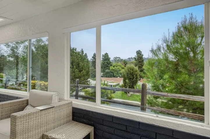 Panoramic view from the rear patio of the neighborhood, trees and hills in the distance.