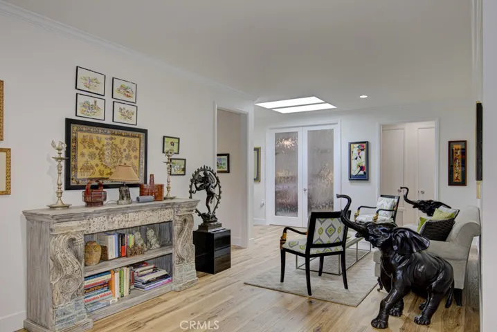 Another view of the entry foyer. French doors at center open to the primary bedroom suite. Open doorway at right leads to the laundry room and service door to the garage.