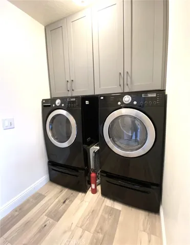 Inside laundry room with washer, dryer and built-in cabinets