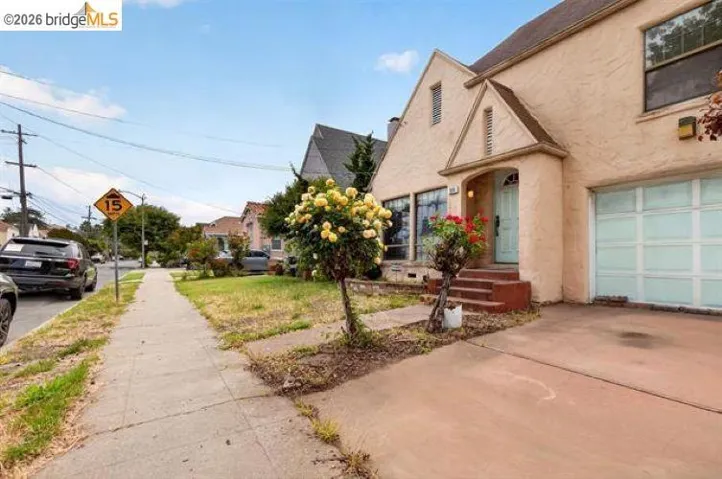 Stucco exterior with a peaked entry portico, an arched front door, and a single-car garage