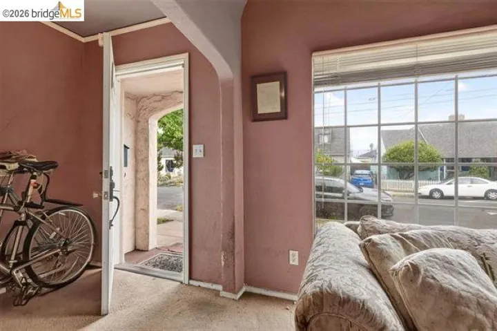 Archway entry with a durable white door, multi-pane window with blinds, and light-toned ceiling