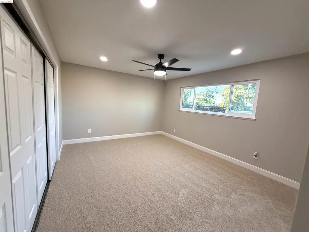 Carpeted flooring, white trim, recessed lighting, ceiling fan, and sliding closet doors Carpeted flooring, white trim, recessed lighting, ceiling fan, and sliding closet doors