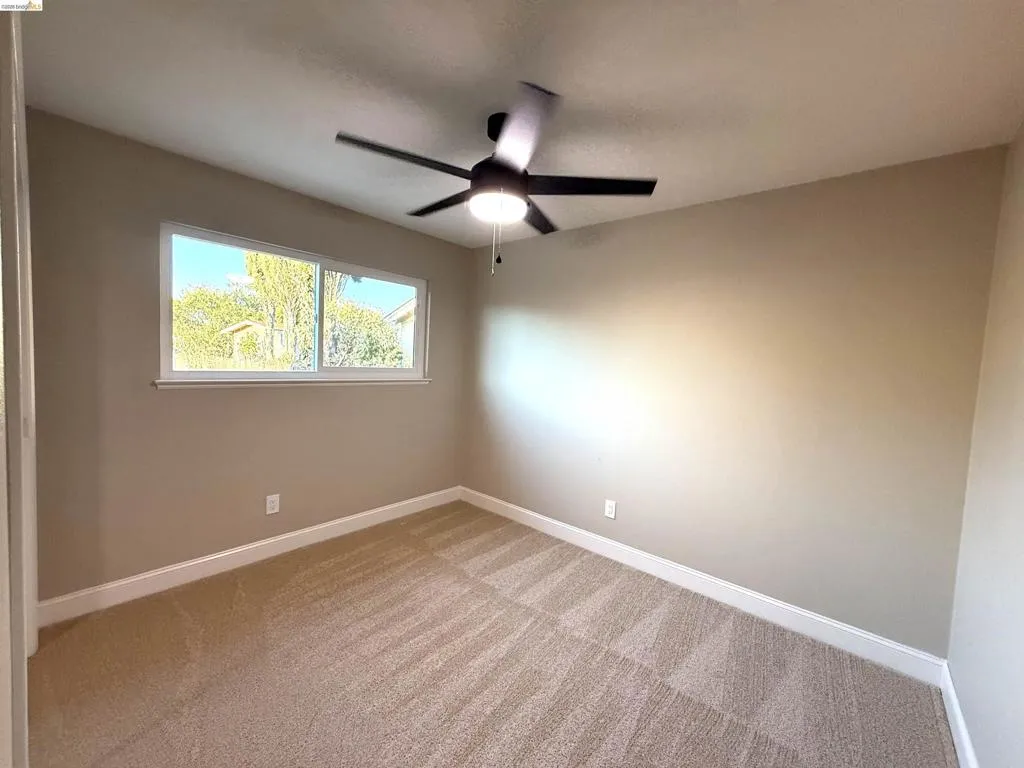 Recessed window with white trim, tan wall paint, ceiling fan, and carpeted flooring Recessed window with white trim, tan wall paint, ceiling fan, and carpeted flooring