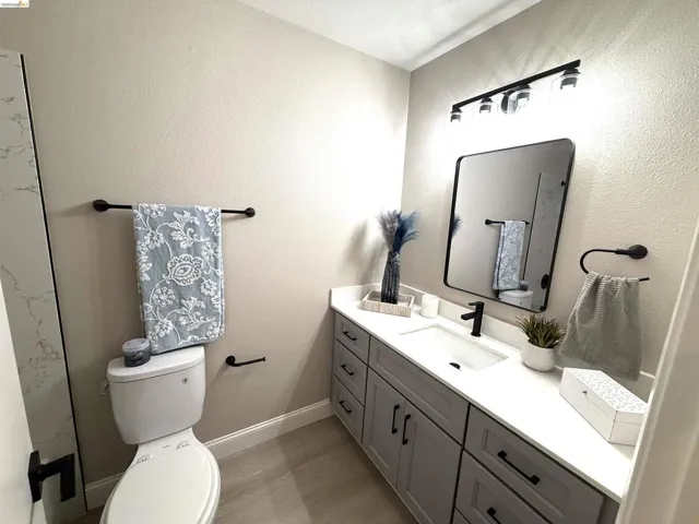 Vanity with white countertop, undermount sink, and matte black faucet