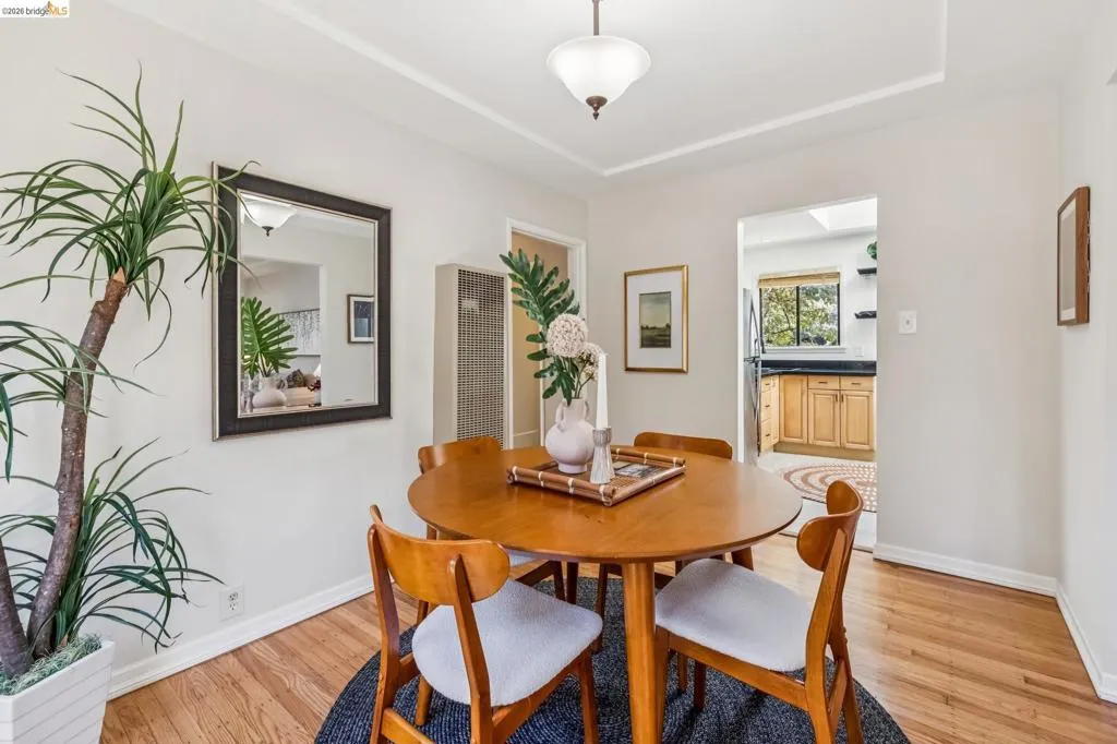 Hardwood flooring, coved ceiling detail, flush mount ceiling light fixture, wall-mounted heater, cased opening to kitchen Hardwood flooring, coved ceiling detail, flush mount ceiling light fixture, wall-mounted heater, cased opening to kitchen
