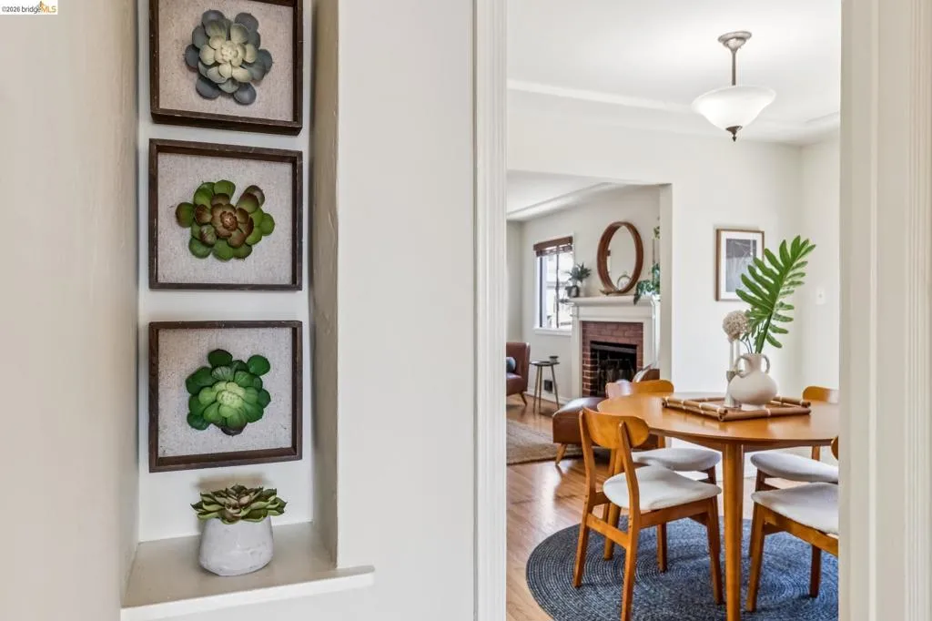 Recessed wall niche, hardwood flooring, brick fireplace, cased doorway, and a flush mount ceiling light fixture Recessed wall niche, hardwood flooring, brick fireplace, cased doorway, and a flush mount ceiling light fixture