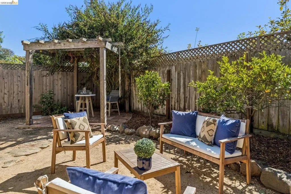 Private backyard featuring a wood pergola, wood fencing with lattice accents, and established plantings Private backyard featuring a wood pergola, wood fencing with lattice accents, and established plantings
