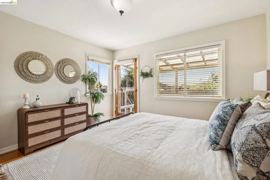 Hardwood flooring, painted walls, ceiling-mounted light fixture, and large window with blinds Hardwood flooring, painted walls, ceiling-mounted light fixture, and large window with blinds