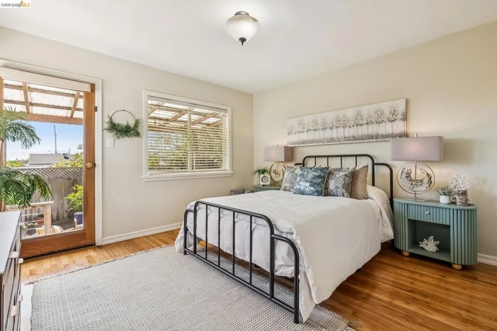 Hardwood flooring, a ceiling-mounted light fixture, and a window with blinds Hardwood flooring, a ceiling-mounted light fixture, and a window with blinds