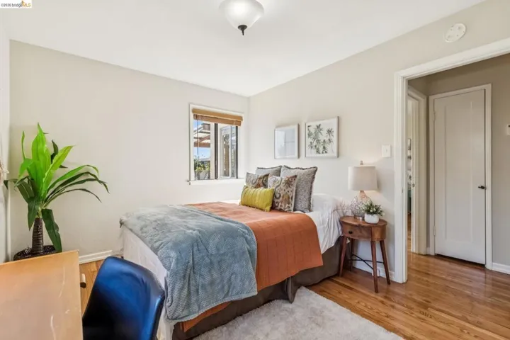 Wood-finish flooring with a white area rug