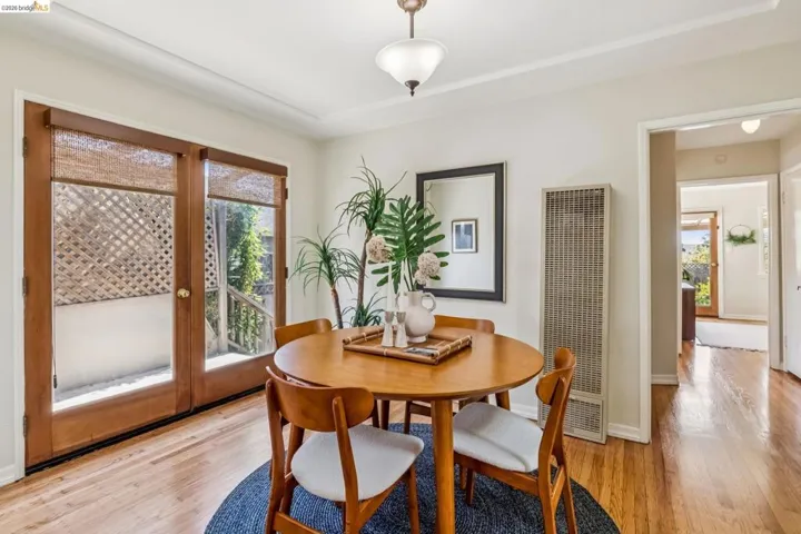 Wood-finish flooring, full-light French doors with woven blinds, and a built-in wall heater