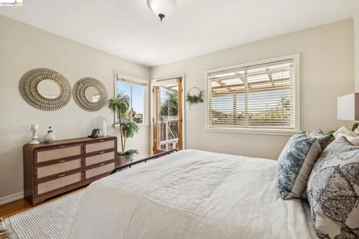 Hardwood flooring, painted walls, ceiling-mounted light fixture, and large window with blinds
