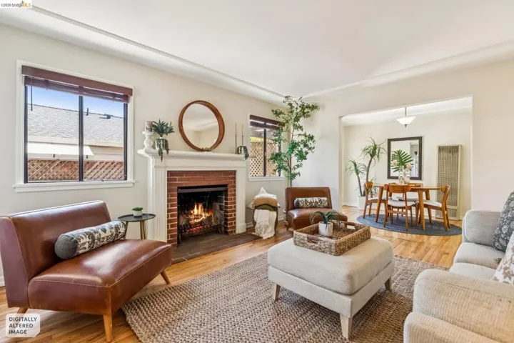 Hardwood flooring throughout, brick fireplace with a white mantel, white crown molding, recessed archway, and a ceiling-mounted light fixture