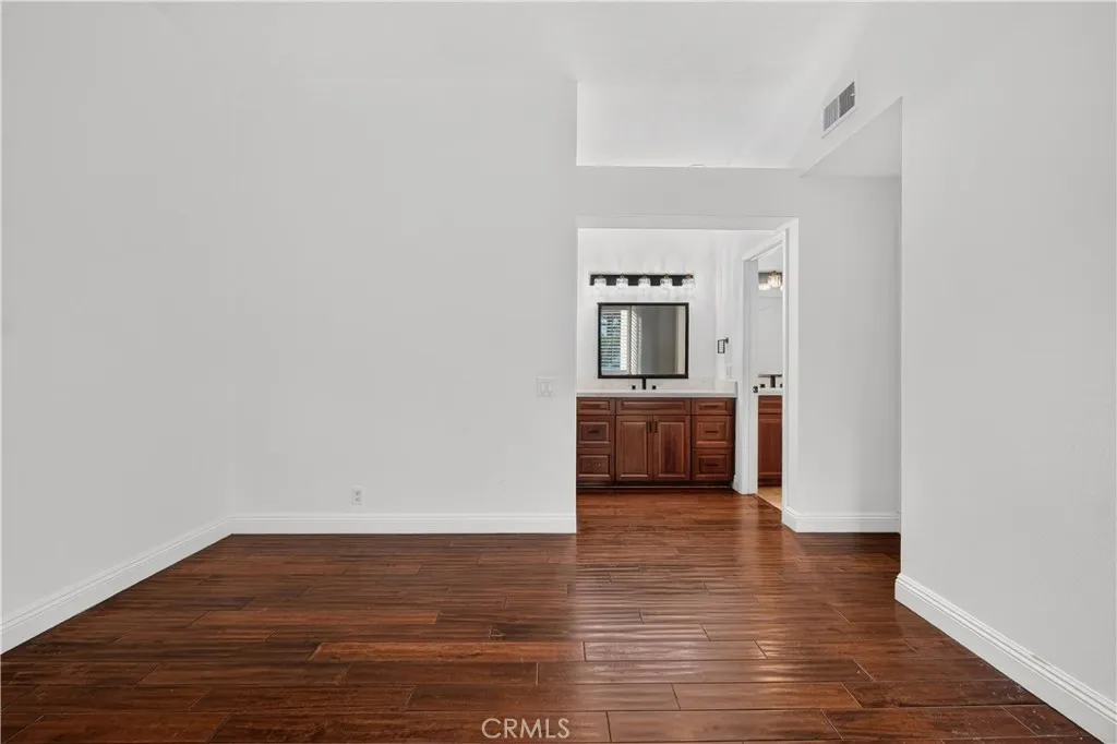 Primary bedroom with walk-in closet and sink with cabinet