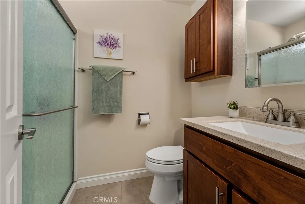 Primary ADU bathroom with standup shower, quartz countertops, and custom cabinetry.