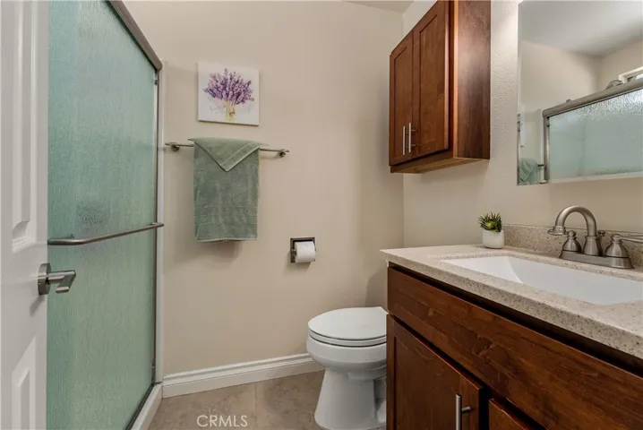 Primary ADU bathroom with standup shower, quartz countertops, and custom cabinetry.