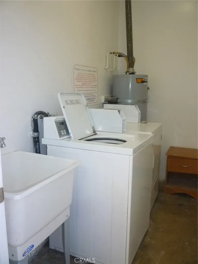 Inside the community laundry room with one washer and one dryer plus a utility sink. Inside the community laundry room with one washer and one dryer plus a utility sink.